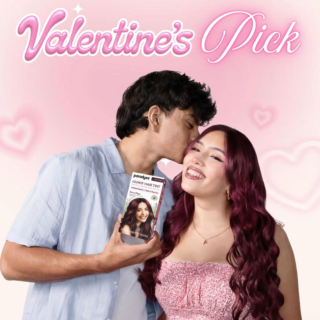 Couple posing together on a pink Valentine’s-themed background, showcasing glossy burgundy hair colour with Paradyes Glossy Hair Tint.